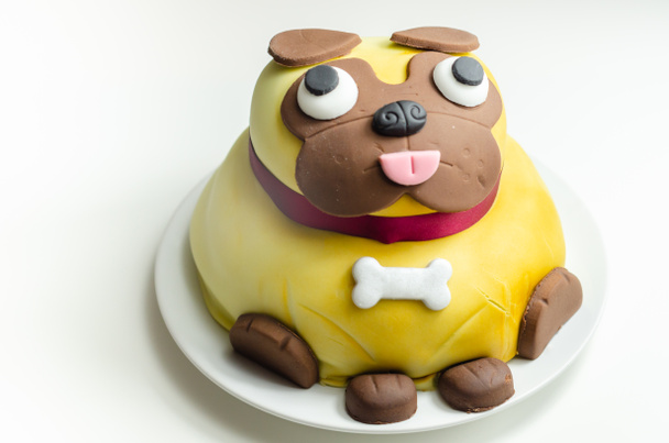 Pug dog cake, sponge with a frosting and raspberry jam filling, covered and decorated with soft icing and edible decorations, birthday cake - Photo, Image