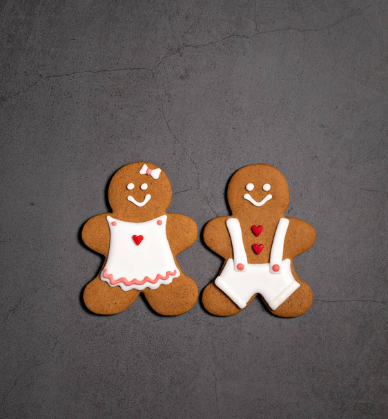 Pár tradičních vánočních perníkových sušenek. Muž a žena na šedém pozadí. Horní pohled, plochá poloha, kopírovací prostor. - Fotografie, Obrázek
