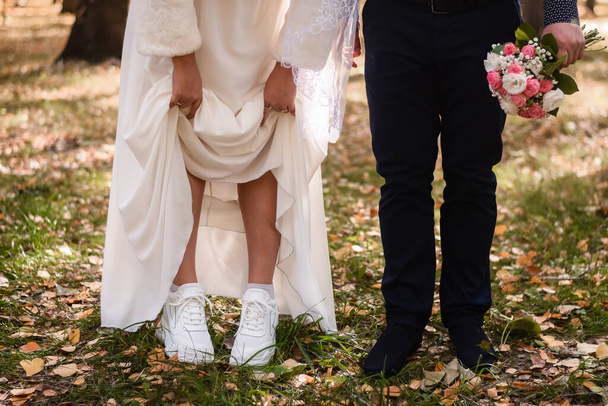the bride lifted her skirt, showing white sneakers. - Fotoğraf, Görsel