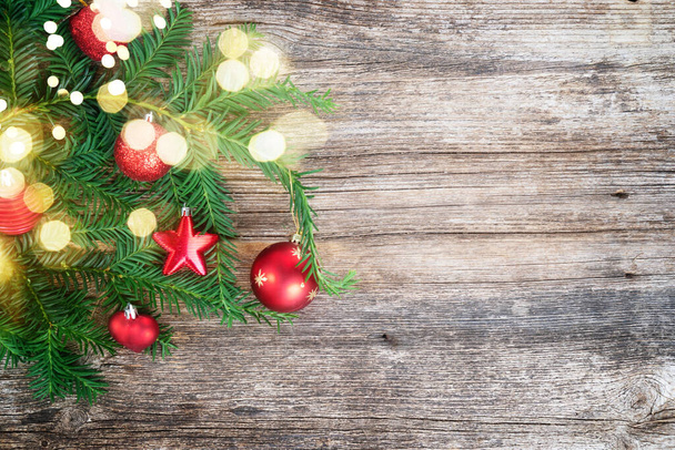 Stile di vita natalizio rustico - ramoscello sempreverde decorato con palline rosse su sfondo di legno invecchiato - Foto, immagini
