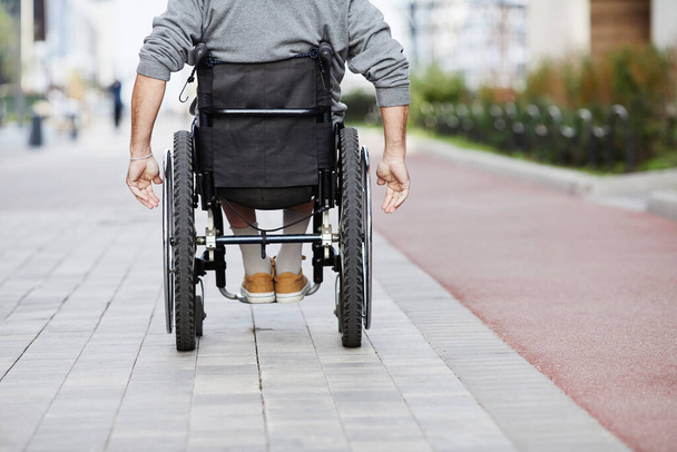 Man in rolstoel rijden buiten - Foto, afbeelding