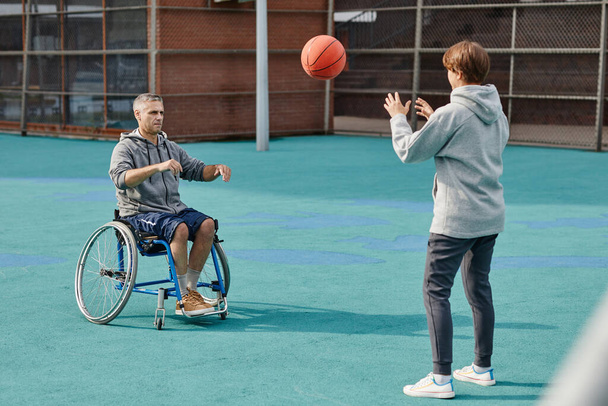 Hombre parapléjico jugando al baloncesto al aire libre - Foto, imagen
