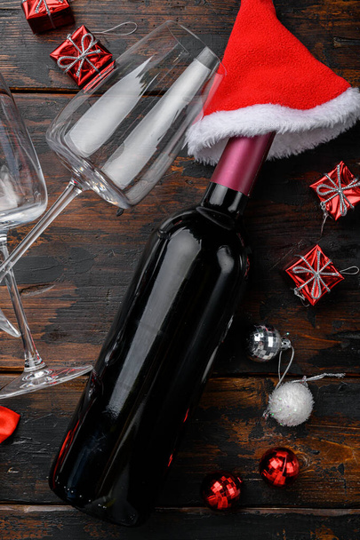 Dekorativní vánoční stolek s lahví vína, na starém tmavém dřevěném stole pozadí, horní pohled byt ležel - Fotografie, Obrázek