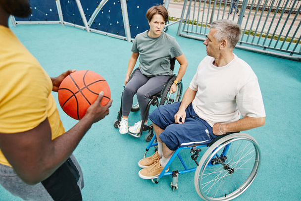 Casal paraplégico conversando com treinador ao ar livre - Foto, Imagem