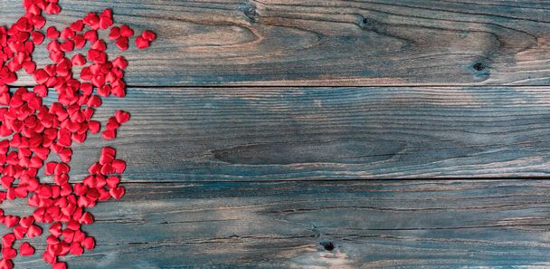 バレンタインデーの休日の背景とともに境界線の小さな心の形で色あせた青い木の板  - 写真・画像