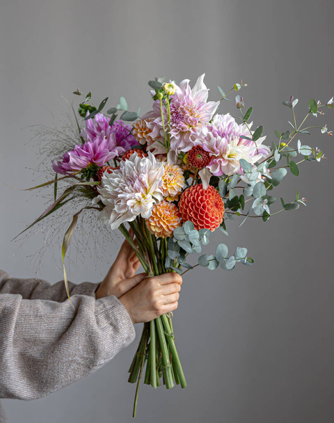 Une femme tient un bouquet festif avec des fleurs de chrysathème dans ses mains. - Photo, image