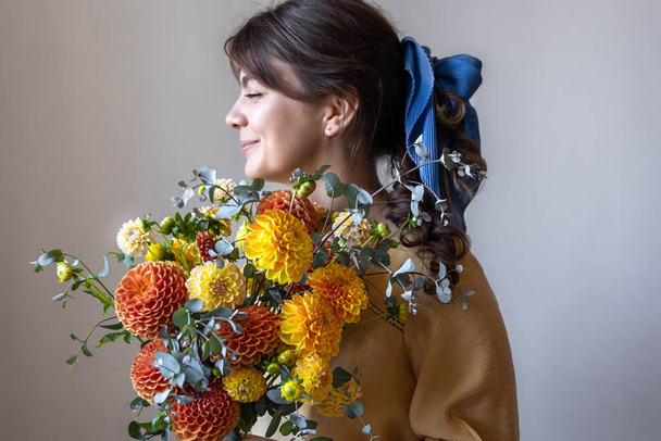 Молодая женщина держит букет цветов хризантем. - Фото, изображение