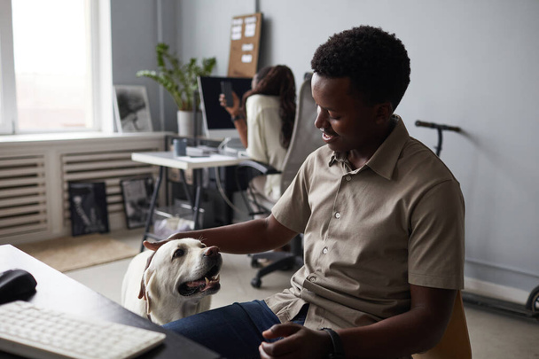 Man Petting Dog in Office - Foto, afbeelding