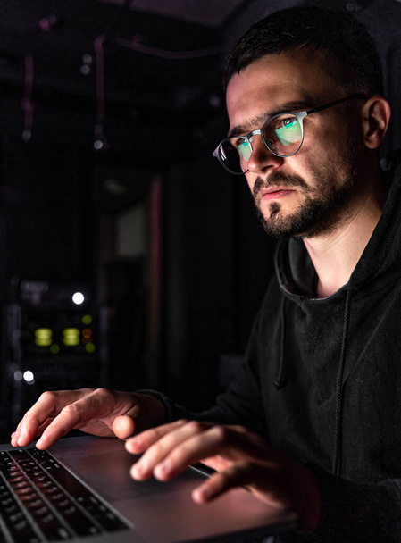 Egy szemüveges férfi dolgozik a számítógépnél késő éjjel.. - Fotó, kép