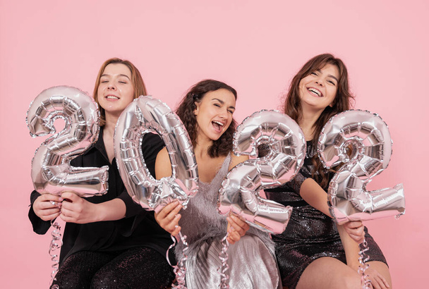 Skupina dívek se stříbrnými fóliovými balónky v podobě čísel 2022. - Fotografie, Obrázek
