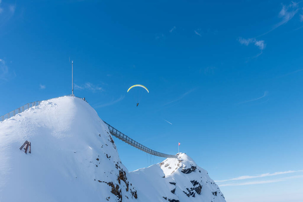 Дві гори з висячим мостом, що зв "язують їх з людиною на небі, перетинають льодовик Діаблет 3000. - Фото, зображення