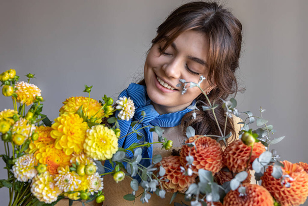 Una giovane donna tiene un mazzo di fiori di crisantemi. - Foto, immagini