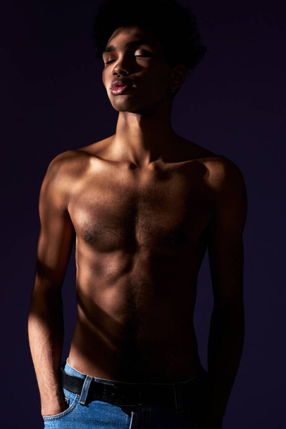 Πορτρέτο του τρανσέξουαλ μοντέλο με κλειστά μάτια σταθεί σε περιστασιακή στάση στη σκιά. Μυϊκό τρανς φύλο - Φωτογραφία, εικόνα