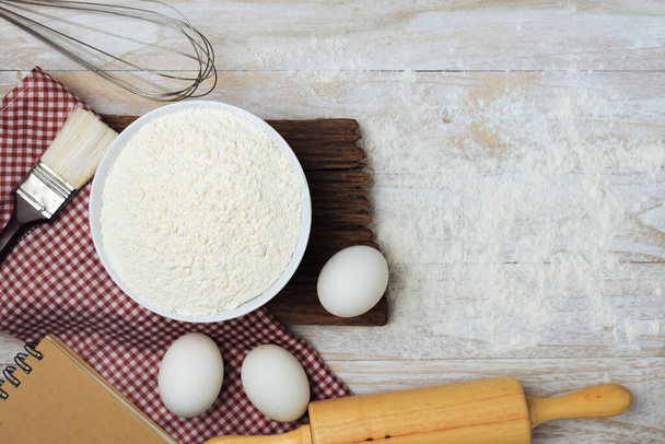Homemade flour mixture, eggs, flour, milk, sugar on a wooden table, viewed from above. - Photo, Image