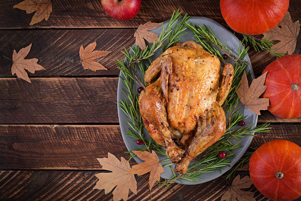 Roasted turkey garnished with cranberries on a rustic style table decorated with pumpkins, apples and autumn leaf. Thanksgiving Day. Flat lay. Top view - Photo, Image