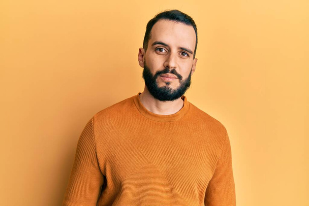 Young man with beard wearing casual winter sweater relaxed with serious expression on face. simple and natural looking at the camera.  - Photo, Image