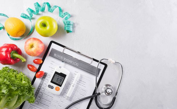 糖尿病の日と医療の概念。糖尿病測定セット、患者の血糖コントロールと石の背景にプレートで健康食品栄養を食べる. - 写真・画像