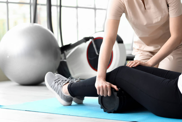Mature woman training with physiotherapist on mat in rehabilitation center - Photo, Image