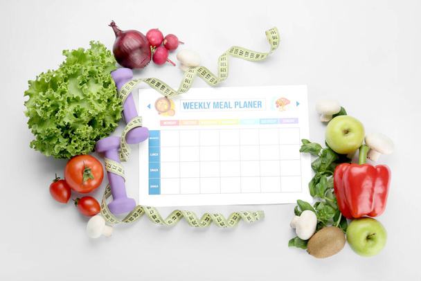 Productos saludables, plan de comidas, pesas y cinta métrica sobre fondo blanco - Foto, imagen