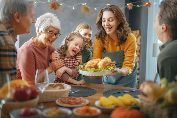 Thanksgiving Day, Autumn feast. Happy family sitting at the table and celebrating holiday. Grandparents, mother, father and children. Traditional dinner. - Foto, Imagem
