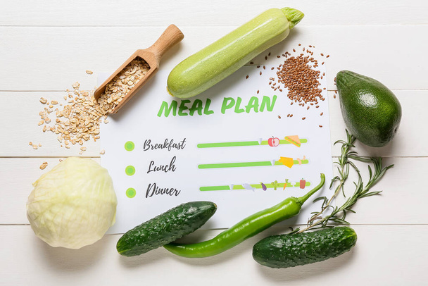 Productos saludables y plan de comidas sobre fondo de madera claro - Foto, imagen