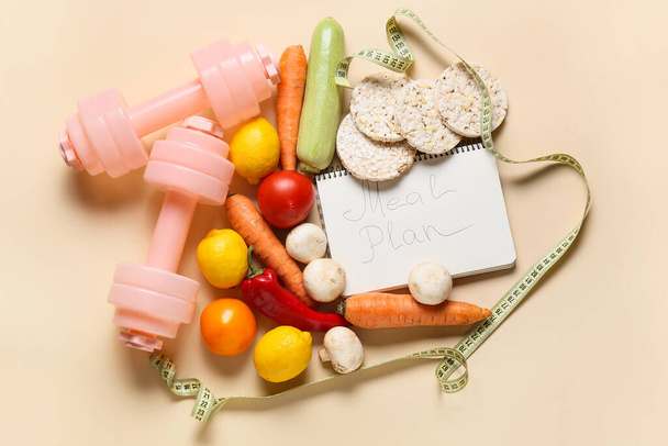 Meal plan with healthy products, measuring tape and dumbbells on color background - Photo, Image