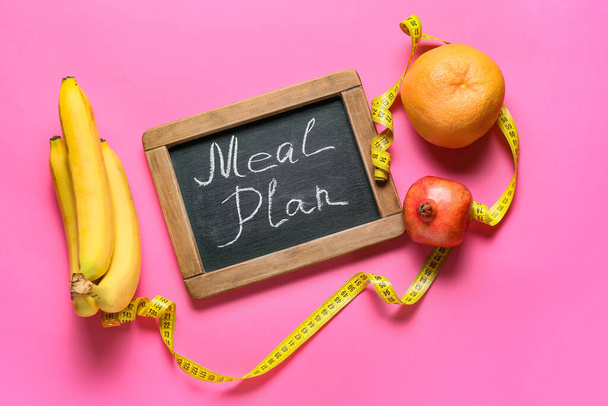 Chalkboard with words MEAL PLAN and fruits on pink background - Photo, Image