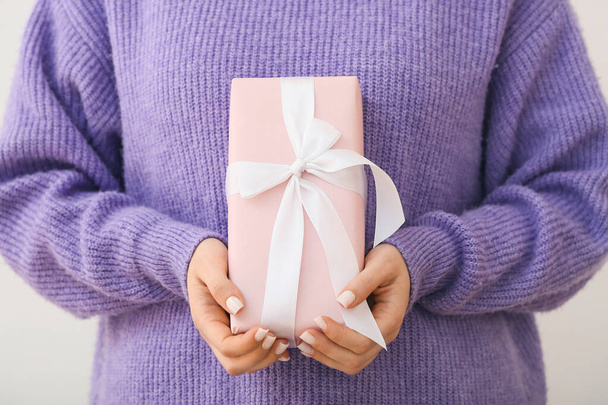 Woman holding gift box on white background, closeup - Photo, image