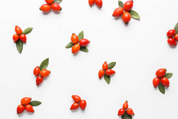 Composition with fresh rose hip berries on white background - Фото, изображение
