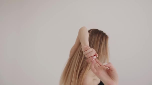 Una bella ragazza è impegnata in stretching in uno studio bianco e fa movimenti lisci con le mani. Concetto di armonia ed equilibrio - Filmati, video
