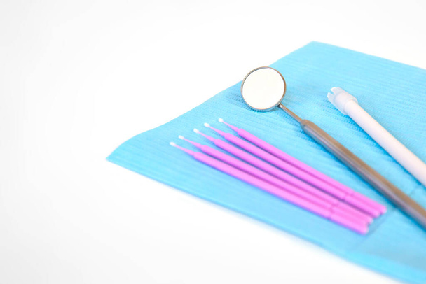 Zahnarztinstrumente, Mikrobürsten liegen auf einem weißen Tisch auf einer Serviette. Pflege- und Präventionskonzept. Raum für Text. - Foto, Bild