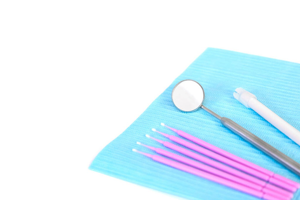 Instrumenty dentystyczne, mikropędzle leżą na białym stole na serwetce. Koncepcja opieki i zapobiegania. Kopiuj miejsce na napis. - Zdjęcie, obraz