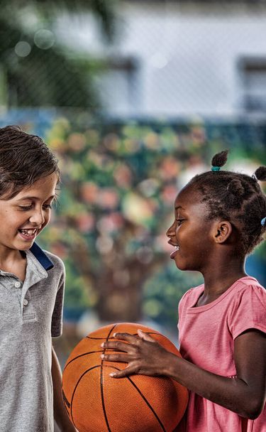 Bambini piccoli che giocano a basket a scuola
. - Foto, immagini