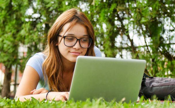 tiener meisje met behulp van laptop outdoor. - Foto, afbeelding