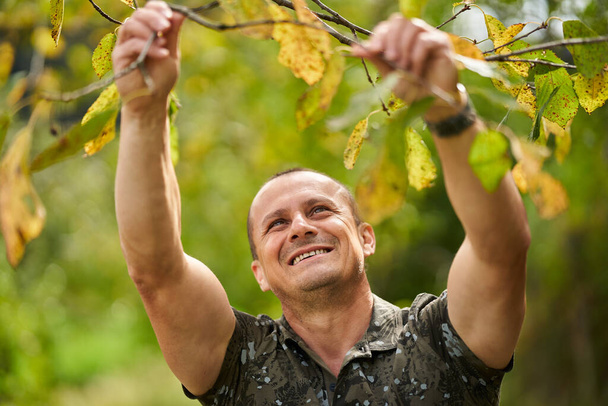 Portrait of a middle aged man in the orchard, early autumn - Fotografie, Obrázek