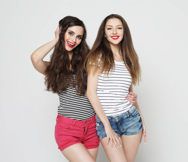 lifestyle and people concept: Two young women friends standing together and having fun. - 写真・画像