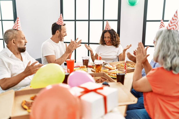 Gruppo di amici di mezza età sorridenti felice festeggiare il compleanno a casa. - Foto, immagini