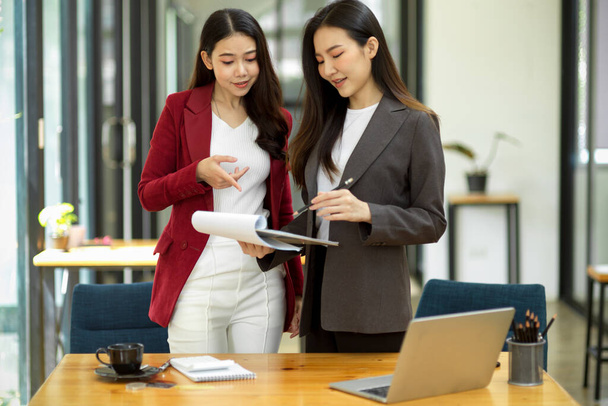 A professional female executive provides advice and mentoring on the work project of her staff in the modern office. - Photo, image