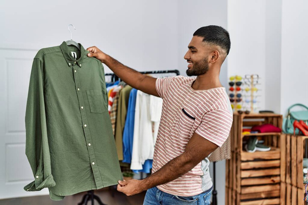 Young middle east man smiling confident shopping at clothing store - Photo, Image