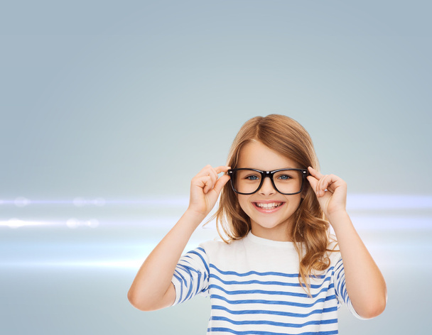 smiling cute little girl with black eyeglasses - Photo, Image