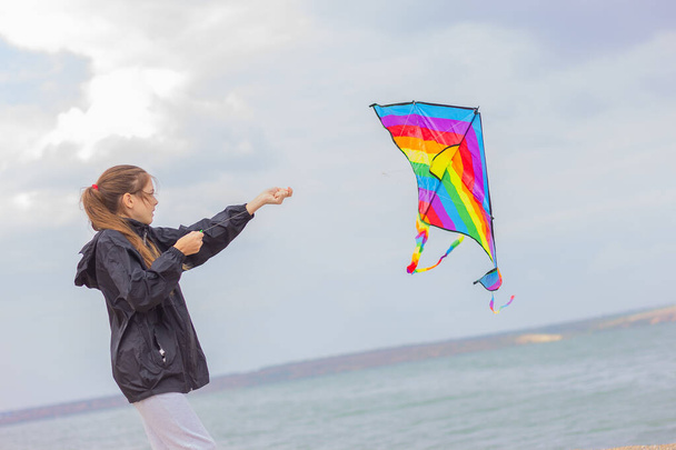 dziewczyna uruchamia kolorowe jasny latawiec w niebo - Zdjęcie, obraz