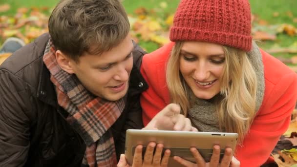 Couple caucasien tablette sans fil dans le parc
 - Séquence, vidéo