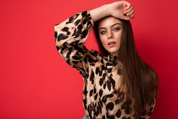 Muoti kuva nuori kaunis muodikas seksikäs brunette nainen yllään tyylikäs leopardi pusero eristetty punaisella taustalla tyhjä tila - Valokuva, kuva