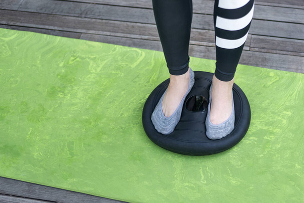 Girl stands on the balancing disc. Close up. Balance exercise. Healthy lifestyle - Photo, Image