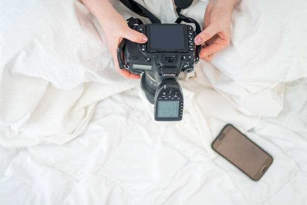 Γυναίκα φωτογράφος κρατά φωτογραφική μηχανή με φλας. Στο πάνω μέρος. Κάμερα SLR. Εξοπλισμός φωτογράφων - Φωτογραφία, εικόνα