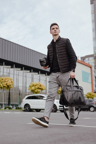 Man walking in city with black leather bag - Foto, Bild