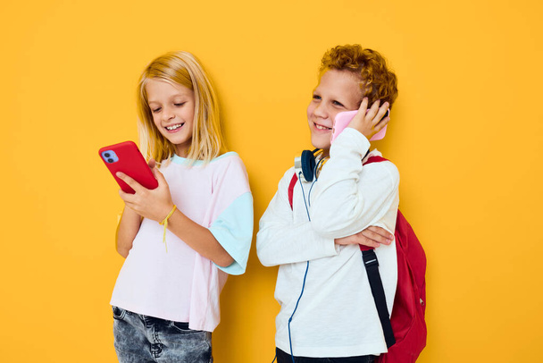 tizenéves fiú és lány nézi a telefon szórakoztató kommunikáció elszigetelt háttér - Fotó, kép