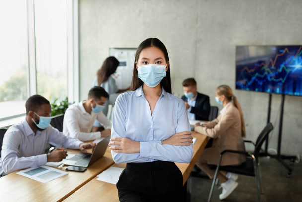 Covid-19 And Entrepreneurship. Portrait of confident young asian businesswoman in medical mask - Foto, Imagen