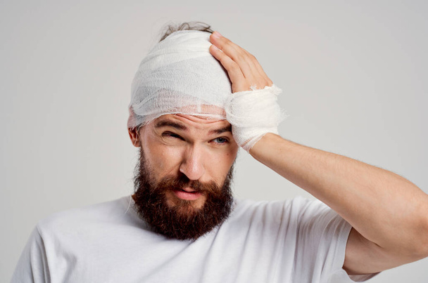 Mann mit bandagiertem Kopf auf isoliertem Hintergrund. Hochwertiges Foto - Foto, Bild