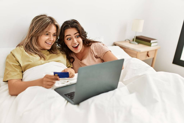 Young couple buying using credit card and laptop at bedroom - Photo, image